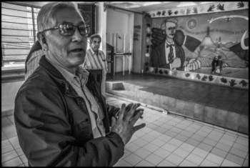 Benedicto Martínez in the offices of the FAT in Mexico City points to a mural by Mike Alewitz celebrating the binational solidarity partnership between the FAT and the United Electrical Workers David Bacon