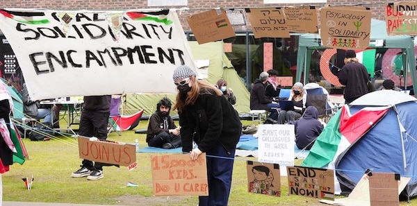 A student adjusts a sign at an encampment on the grounds of Newcastle University, protesting against the war in Gaza, May 2, 2024