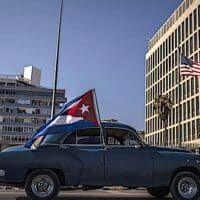 A classic American car flying a Cuban flag drives past the US embassy during a rally calling for the end of the US blockade against Cuba. Photo: AP/Ramon Espinosa.