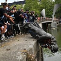 Protesters throw the statue of merchant and slave trader Edward Colston into Bristol harbour during a Black Lives Matter protest rally, 2020