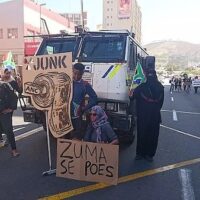 Anti-Zuma protestors in Cape Town complaining of the junk status that South African debt became valued at during the Zuma presidency. The term “se poes” is a slang insult in Cape Town (7 April 2017).