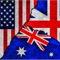 USA, Britain and Australia painted flags on wall with crack. United States of America, United Kingdom and Australia relations.