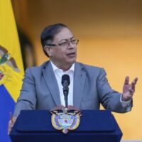 Colombian President Gustavo Petro standing in front of the flag of Colombia and giving a speech at a podium. File photo.