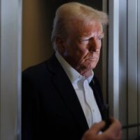 US President Donald Trump listens to reporters’ questions aboard Air Force One on 25 January 2025 (Reuters)