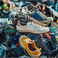 Photo by stockcake, discarded shoes and clothing, overproduction