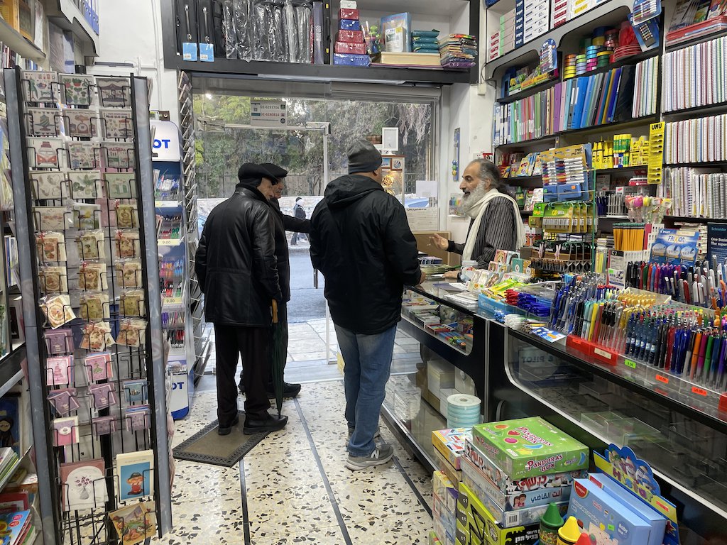 Iyad Muna speaks with customers in the Educational Bookshop's Arabic-language storefront in Jerusalem.