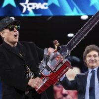 Elon Musk holds up a chainsaw he received from Argentina's President Javier Milei, right, as they arrive to speak at the Conservative Political Action Conference, CPAC, at the Gaylord National Resort & Convention Center, Thursday, Feb. 20, 2025, in Oxon Hill, Maryland. [AP Photo/Jose Luis Magana]