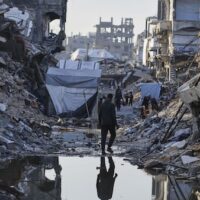 Palestinians walk amid the rubble of destroyed homes and buildings in Jabaliya, northern Gaza Strip on Friday, March 14, 2025. [AP Photo/Jehad Alshrafi]