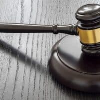 Wood gavel and open handcuffs symbolizing freeing judge decisions