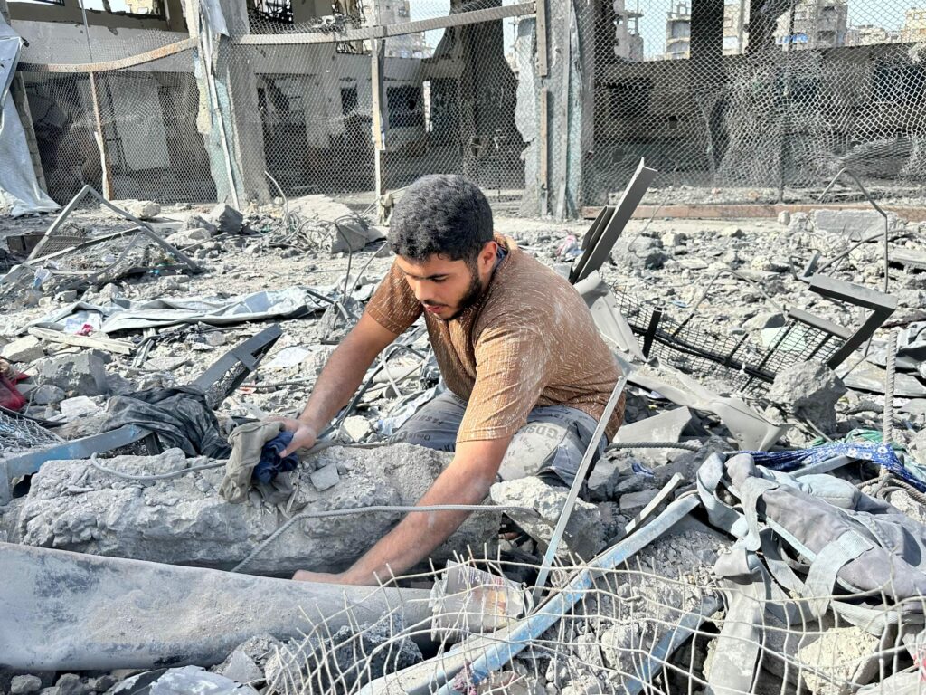 85f82c0ac8e94988b23a2ebac2969e773490x2617 | MR Online Al Moatassem Shalayel 20 digging through the rubble in the aftermath of an Israeli airstrike on an UNRWA building in Jabaliya refugee camp that killed four people including his uncle May 10 2025 Photo by Hamza Salha