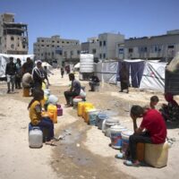 Palestinian children wait in line to collect water in Gaza City, May 24, 2025