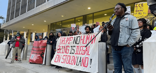 MR Online | Carlos Sirah of Black Alliance for Peace SoCal speaks as community groups in Los Angeles unite against ICE Photo by Abraham Marquez for LA TACO | MR Online
