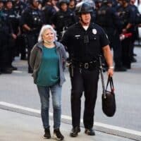 An LAPD officer escorts a protester during mass arrests at an anti-ICE demonstration in Los Angeles, June 10, 2025. Marcio Jose Sanchez | AP