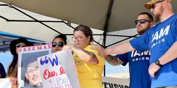 MR Online | Crystal Londonio wife of detained Machinist Max Lodonio speaks at the June 6 rally Richard Howard the president of her husbands Machinists local is at right in hat with another local member Photo Zack Pattin | MR Online