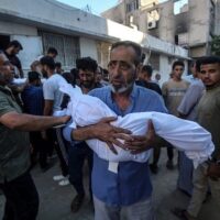 A PALESTINIAN MAN CARRIES THE BODY OF A BABY KILLED IN AN ISRAELI ATTACK ON AL-SHATI CAMP, AT THE MORGUE OF AL SHIFA HOSPITAL IN GAZA CITY, GAZA ON JULY 9, 2025. (PHOTO: OMAR ASHTAWY/APA IMAGES)