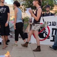 Israeli teenagers burning draft orders at Habima Square in Central Tel-Aviv on last Tuesday, July 15, 2025 (Photo: Zo Haderekh)