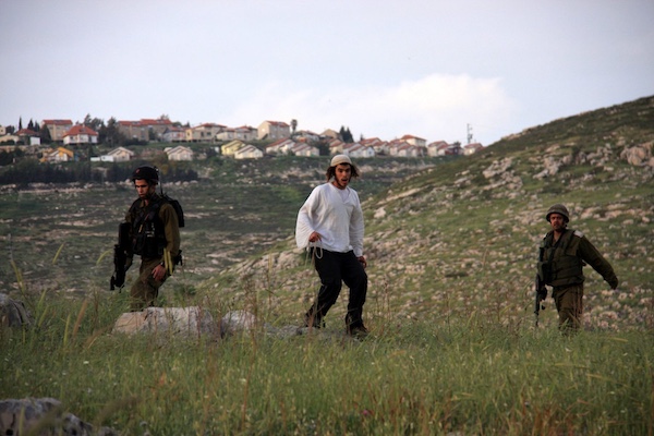  | SETTLER FROM THE HAR BRACHA SETTLEMENT THROWS STONES AT PALESTINIAN VILLAGERS FROM BURIN UNDER PROTECTION OF THE ISRAELI ARMY APRIL 19 2011PHOTO WAGDI ESHTAYAHAPA IMAGES | MR Online