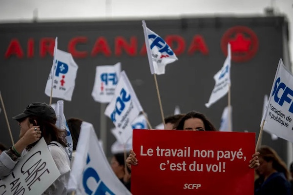 MR Online | Flight attendants protest in front of the Air Canada headquarters in Montreal Canada holding a sign that says Work without pay is theft | MR Online