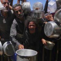 Palestinians struggle to get donated food at a community kitchen in Khan Younis, southern Gaza Strip, September 1, 2025