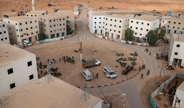 Israeli occupation forces gather at the immersive theater set known as the Urban Warfare Training Center or “Mini Gaza” at Wadi al-Sayal (Tze’elim), an-Naqab (Negev) desert, occupied Palestine, Jan. 4, 2022. Photo: Oded Balilty/Associated Press.