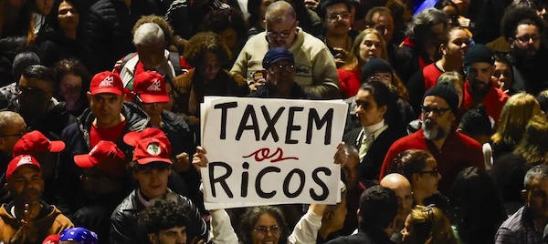 People attend a demonstration in support of taxing the super-rich in São Paulo, Brazil on July 10, 2025. (Photo by Miguel Schincariol/AFP via Getty Images)