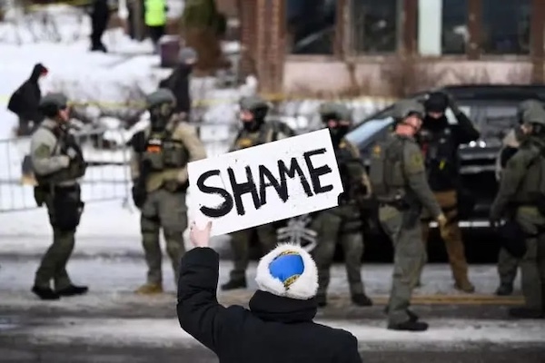 MR Online   A protester holds a sign reading shame at the scene of the shooting in Minneapolis PHOTO Stephen MaturenAFP   MR Online