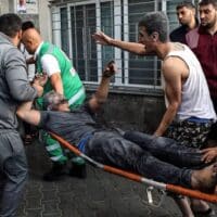 An injured Palestinian man carried into Al-Shifa Hospital in Gaza (Photo: Abed Khaled / Alamy)