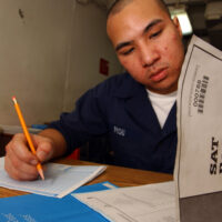 A young man at a desk takes the SAT.