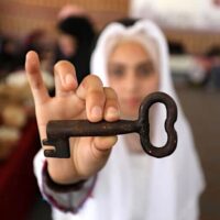 A GIRL HOLDING UP THEY KEY OF RETURN DURING A HERITAGE GALLERY MARKING THE 74TH ANNIVERSARY OF THE NAKBA, GAZA CITY, MAY 12, 2022. (PHOTO: ASHRAF AMRA/APA IMAGES)