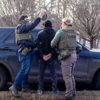 ICE agents search the passenger of a truck as they arrest both him and the driver during a traffic stop Wednesday, Feb. 11, 2026 on Bottineau Blvd. in Robbinsdale. (Photo: Nicole Neri/Minnesota Reformer)