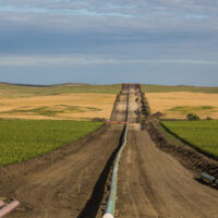 A wide view of the Dakota Access Pipeline extending to the horizon, with expanses of prairie on either side.