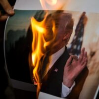 Iranian demonstrators burn a picture of the US President Donald Trump during a protest in front of the former US Embassy on 9 May, 2018 in Tehran, Iran [Majid Saeedi/Getty Image]