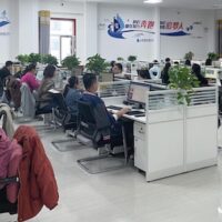 Workers reviewing digital content and data. In China, recent AI-related labor rulings held that employers cannot shift the cost of automation onto workers through firings or forced pay cuts.