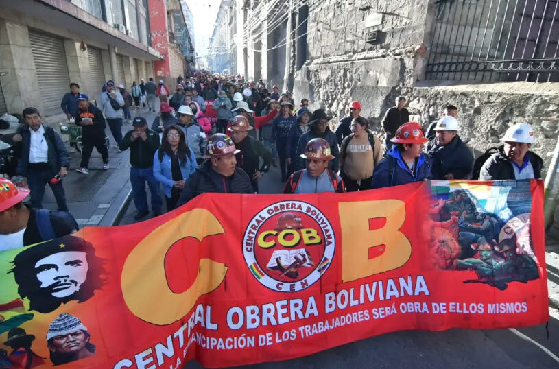 Workers march behind the banner of the Central Obrera Boliviana (COB), Bolivia’s main labor federation, during the general strike against President Rodrigo Paz.