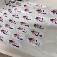 “I voted” stickers rest on a counter at the Pennington County Administration Building during early voting on Jan. 19, 2026, for a municipal election in Rapid City, South Dakota. (Photo by Seth Tupper/South Dakota Searchlight)