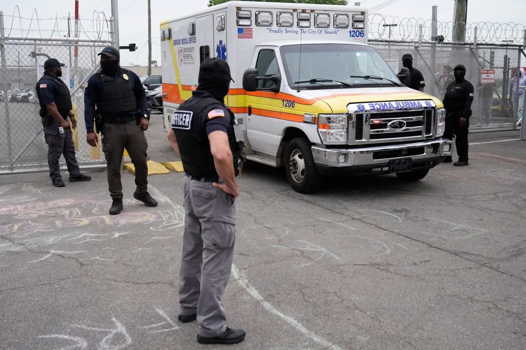 Officers stand outside the Delaney Hall detention center as an ambulance leaves the premises on Wednesday, May 27, 2026, in Newark, N.J. Credit: AP Photo/Seth Wenig