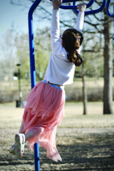 Fiona plays on the monkey bars at a local park.