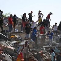 Residents search through earthquake rubble in La Guaira, Venezuela, after the June 24 twin quakes. Years of U.S. blockade left hospitals, public works and rescue capacity weakened before the disaster struck.