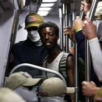 A passenger looks on as members of the white supremacist group Patriot Front ride the Washington Metro on July 4 in Washington, DC. (Photo by Finn Gomez/Getty Images)