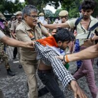Security personnel detain a protestor during a march towards Parliament on July 20. Photo: PTI.
