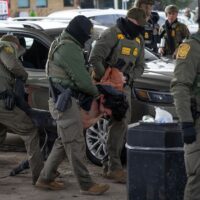 ST. PAUL, MINNESOTA - JANUARY 11: U.S. Border Patrol agents detain Orbin Mauricio Henriquez Serrano after he failed to present citizenship documentation at a gas station on January 11, 2026 in St. Paul, Minnesota. Then-Border Patrol Commander Gregory Bovino watches in the background. (Photo by Scott Olson/Getty Images)