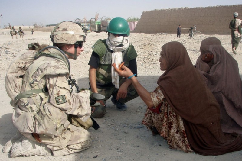 A Canadian soldier and an interpreter from the Kandahar Provincial Reconstruction Team speak with an Afghan woman from the village of Panjwayi in Afghanistan in 2007. Photo by Cpl. Simon Duchesne.