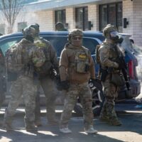Several federal agents gather as people protest near the scene of 26th Street West and Nicollet Avenue in Minneapolis, where federal agents shot and killed Alex Pretti Saturday, Jan. 24, 2026. (Photo by Nicole Neri/Minnesota Reformer)