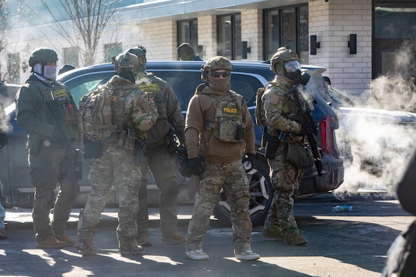 Several federal agents gather as people protest near the scene of 26th Street West and Nicollet Avenue in Minneapolis, where federal agents shot and killed Alex Pretti Saturday, Jan. 24, 2026. (Photo by Nicole Neri/Minnesota Reformer)