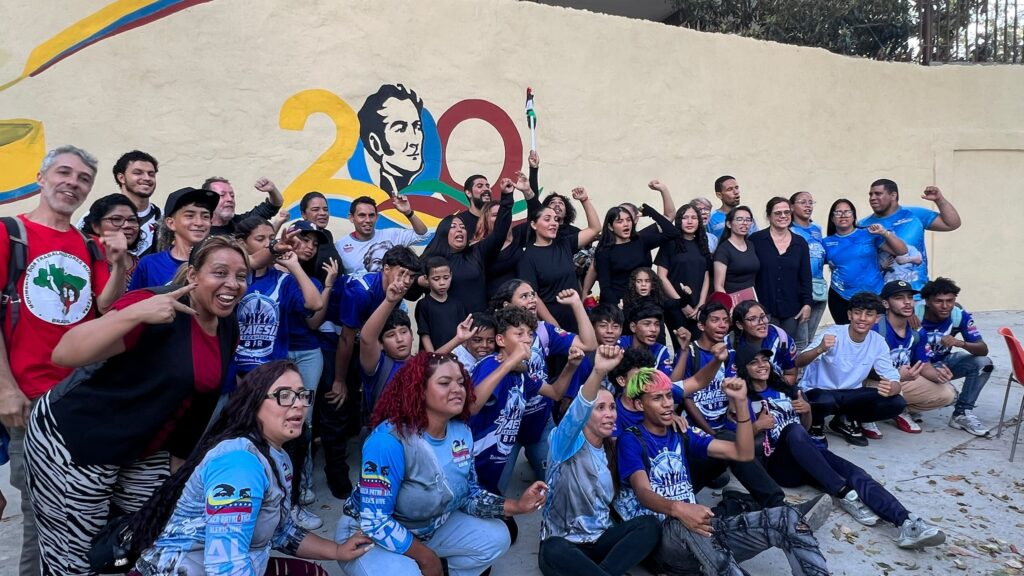 A group of people standing in rows, raising their fists.