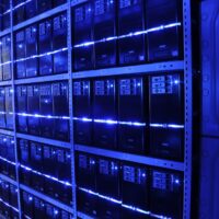 Server racks in a data center, bathed in blue light.
