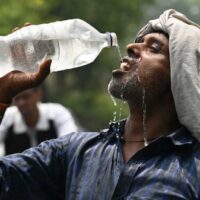 A worker cools off with water during extreme heat in Amritsar, India. El Niño raises the temperature, but who survives the heat is decided by wages, housing, electricity, health care and the conditions capitalism imposes on working people.