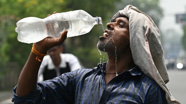 A worker cools off with water during extreme heat in Amritsar, India. El Niño raises the temperature, but who survives the heat is decided by wages, housing, electricity, health care and the conditions capitalism imposes on working people.