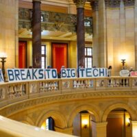 Demonstrators hold up signs protesting tax breaks for data centers during a special legislative session Monday, June 9, 2025 at the Minnesota State Capitol in St. Paul. (Photo by Nicole Neri/Minnesota Reformer)