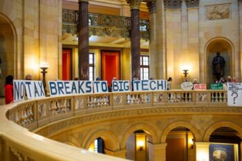 Demonstrators hold up signs protesting tax breaks for data centers during a special legislative session Monday, June 9, 2025 at the Minnesota State Capitol in St. Paul. (Photo by Nicole Neri/Minnesota Reformer)